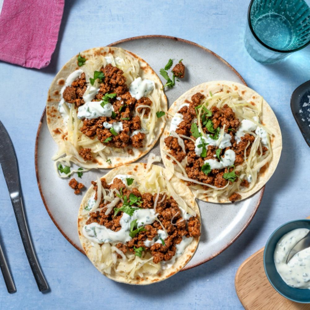 Tacos fotografati dall'alto sul tavolo, tra posate e tovaglioli